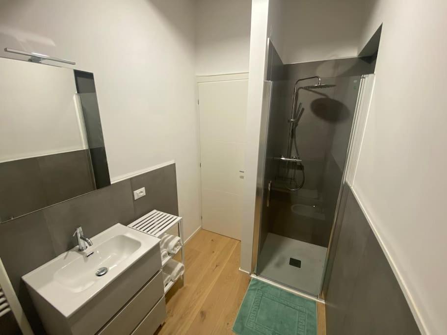 Bagno con doccia e pavimento in parquet